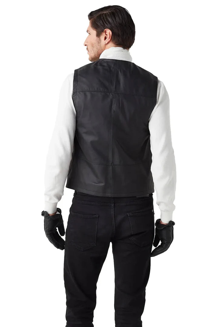 Man wearing a black leather vest over a white shirt on a white background