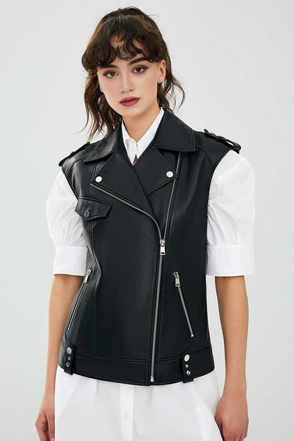 Woman wearing a black leather vest over a white shirt on a light gray background