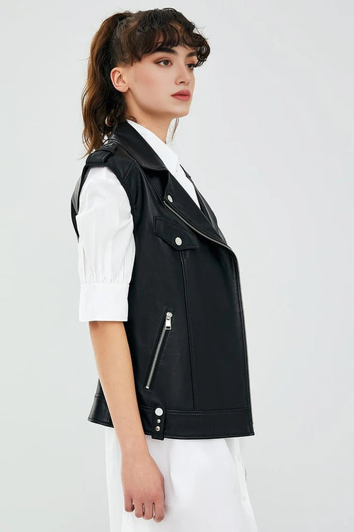 Woman wearing a black leather vest over a white shirt on a light gray background