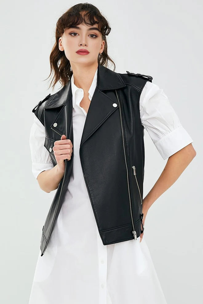 Woman wearing a black leather vest over a white shirt on a light gray background