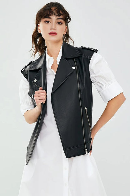 Woman wearing a black leather vest over a white shirt on a light gray background
