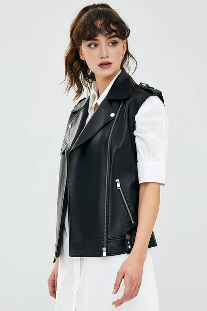 Woman wearing a black leather vest over a white shirt on a light gray background