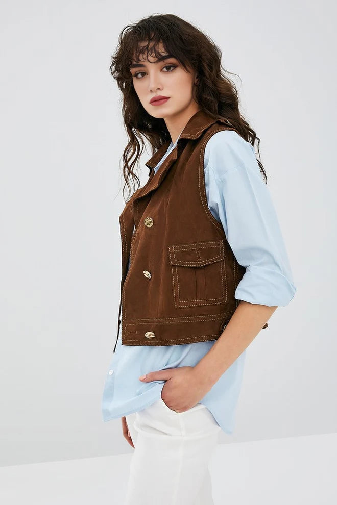 Woman wearing a brown vest over a light blue shirt on a white background